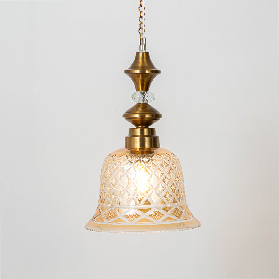 Classic pendant light in gold metal finish with patterned glass shade for dining room or living decor lighting white background.