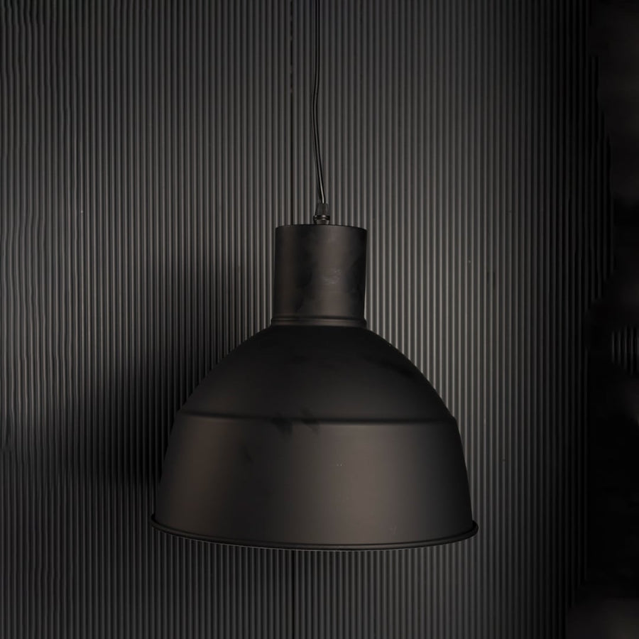 Sleek black industrial pendant light fixture turned off isolated on a pitch black background for a dramatic contrast look.