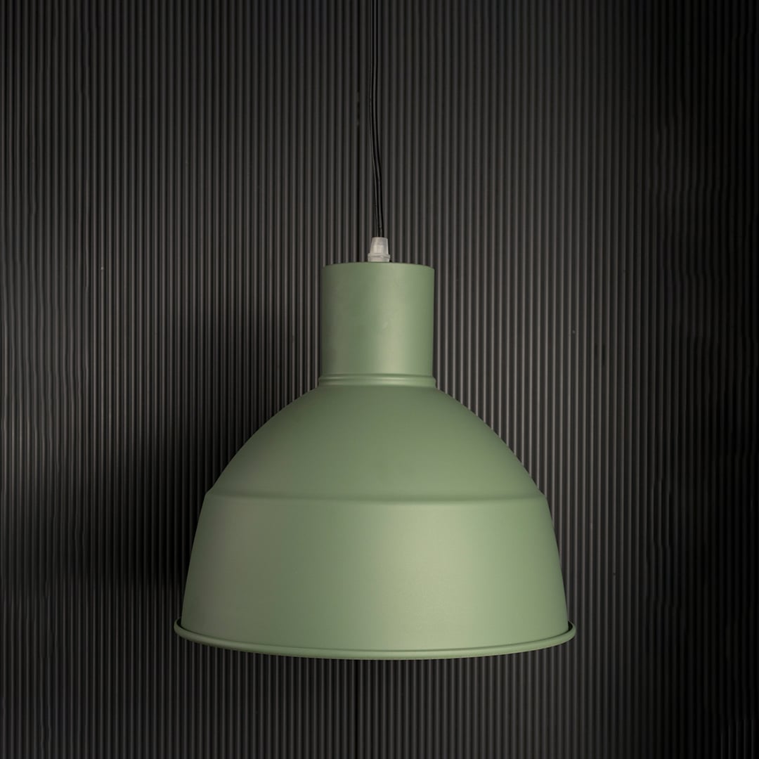 Sleek green industrial pendant light fixture turned off isolated on a pitch black background for a high contrast and dramatic presentation.