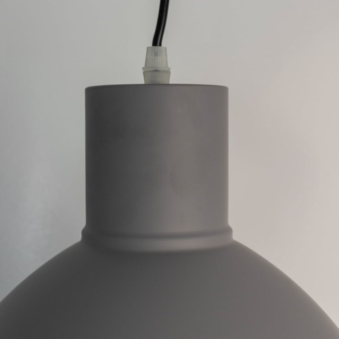 Closeup of grey pendant light showing smooth matte texture and refined modern detailing.