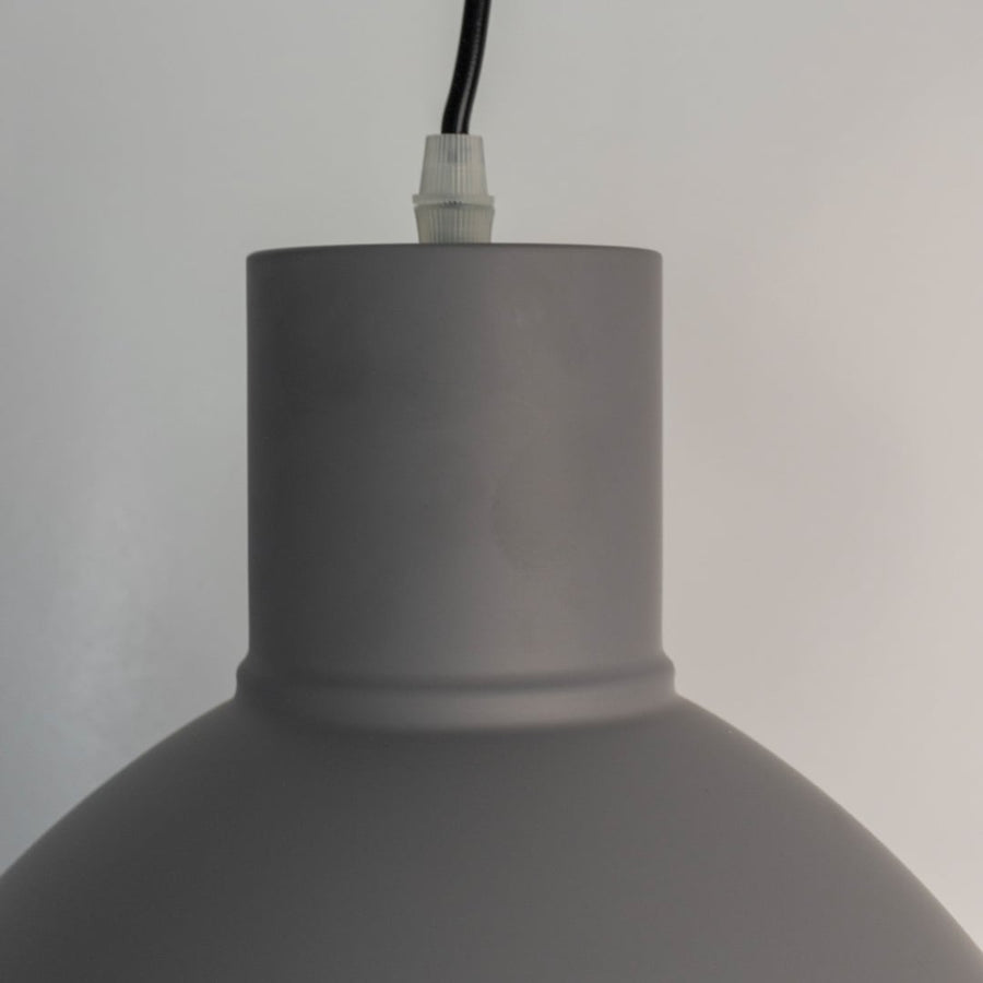 Closeup of grey pendant light showing smooth matte texture and refined modern detailing.