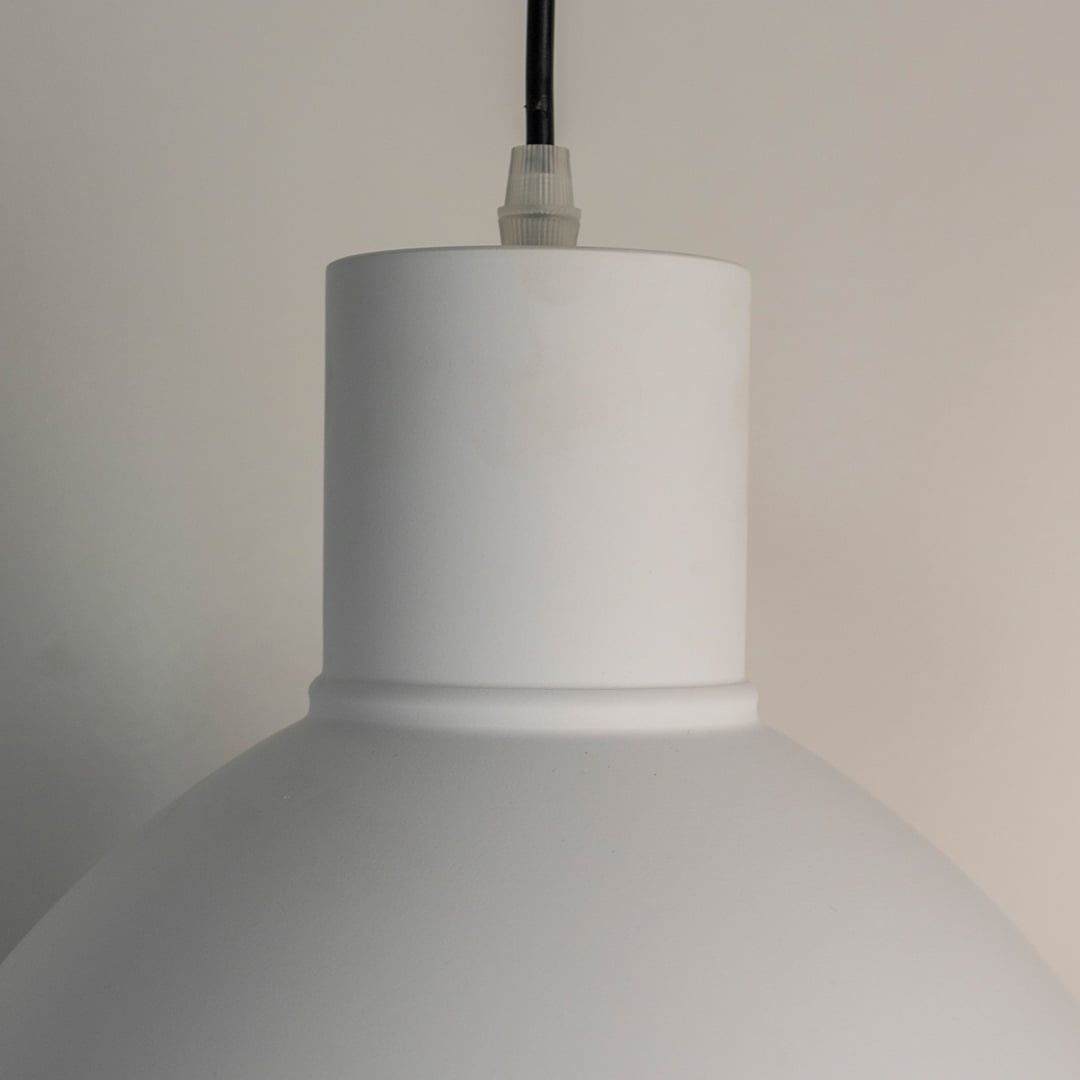 Closeup of white metal pendant light showcasing smooth finish and minimalist Scandinavian design details.