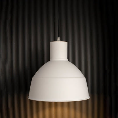 Illuminated white metal dome pendant lamp turned on suspended against a dark black background highlighting the rim shape and warm light emission