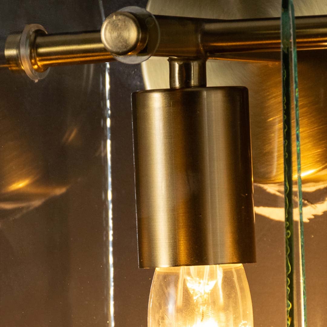 Closeup of glorious gold metal and glass wall sconce displaying smooth finish clear glass shade and elegant indoor wall lighting presence.