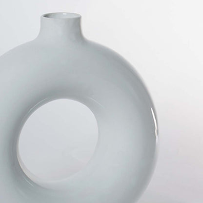 A closeup view of the white circular vase highlighting its smooth glossy texture and detailed rounded edges enhancing its clean modern sculptural look.