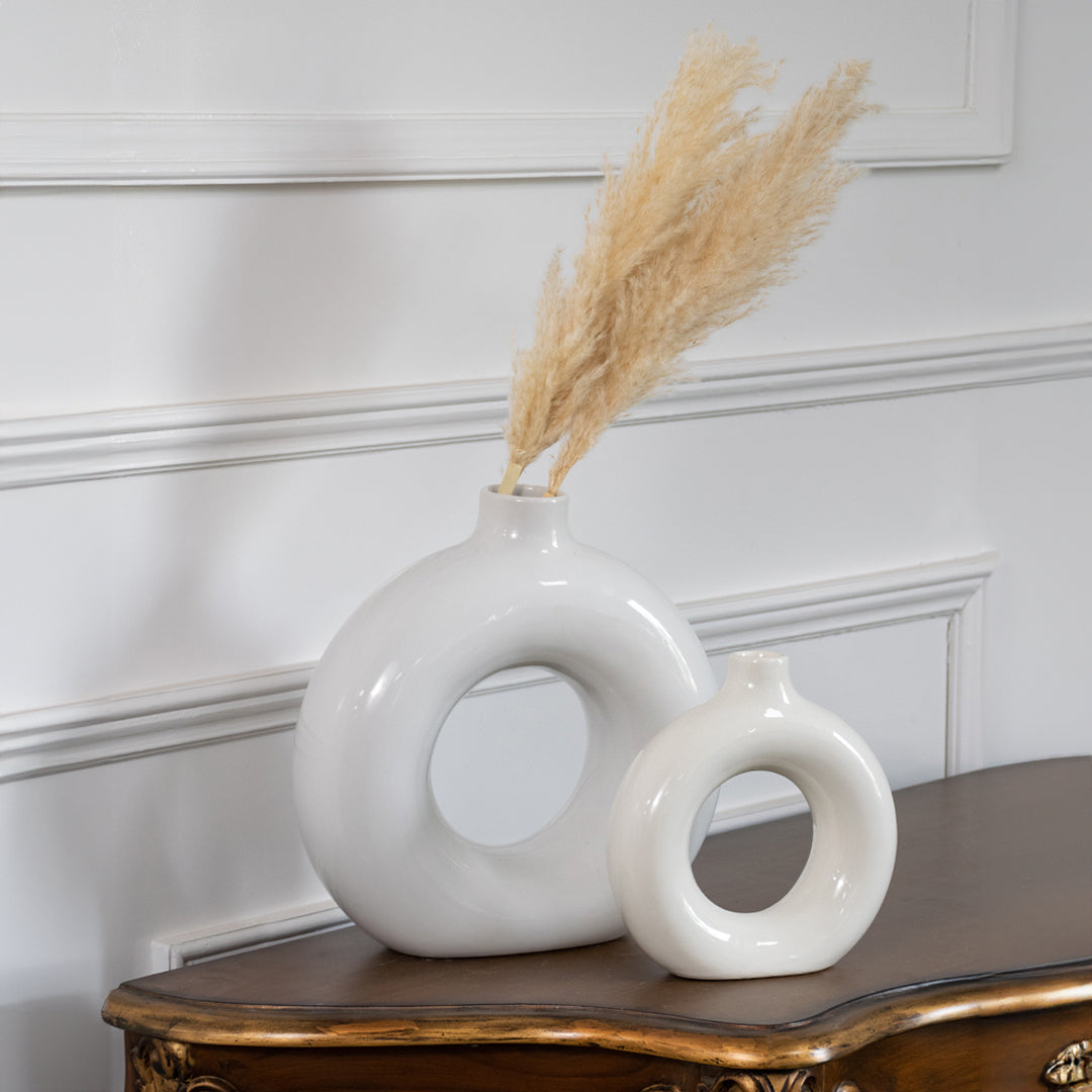 White and blue ceramic ring vase set with dried stems for elegant console table styling and modern home decor.