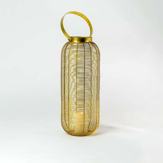 Illuminated gold metal wire lantern with round handle and glowing candle light inside on clean white studio background.