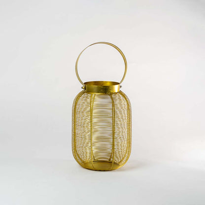 Golden wire lantern placed on a white background with the candle light off highlighting the clear structure and elegant golden finish.