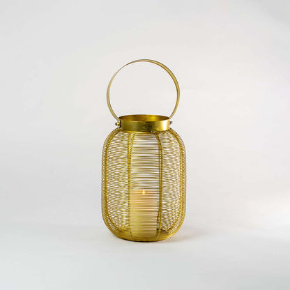 Gold metal mesh lantern with round handle and candle holder for elegant tabletop decor styling.