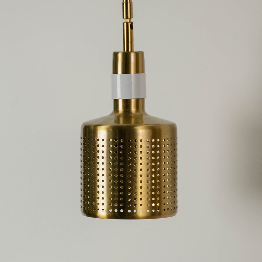 Gold perforated metal pendant light with cylindrical shade modern hanging lamp for kitchen dining room stylish decor lighting.