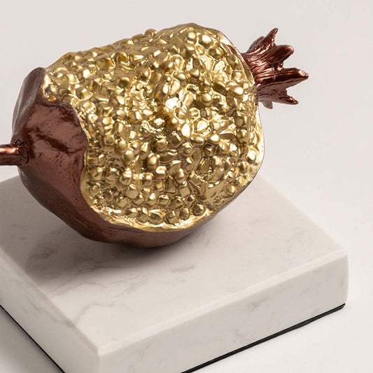 Closeup of decorative gold textured fruit sculpture with metallic finish highlighting handcrafted detailing for luxury home decor accent.