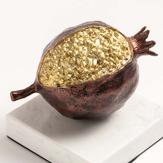 Closeup of gold textured decorative pomegranate sculpture showcasing premium craftsmanship and elegant styling details.