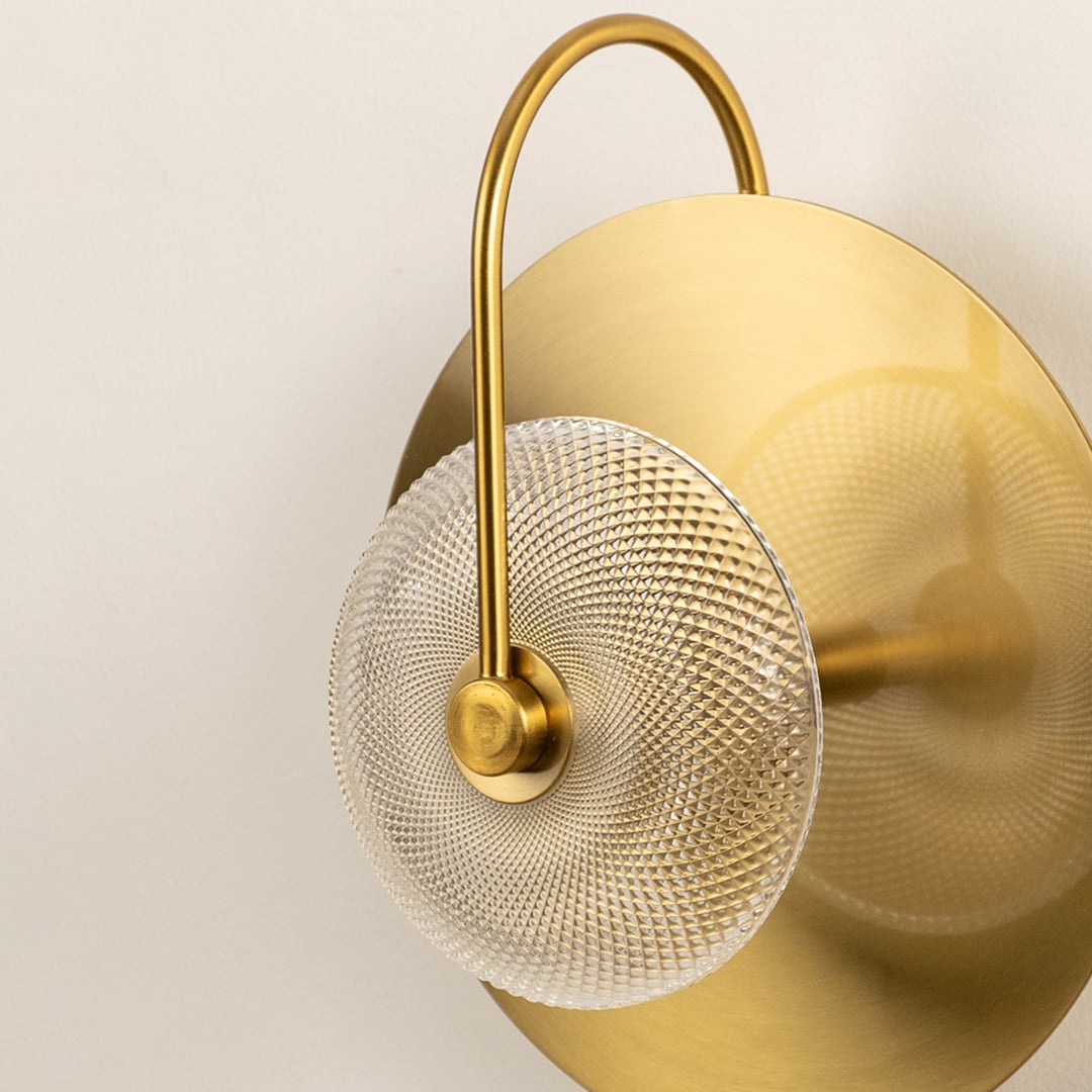 Closeup of textured glass and gold metal wall light for modern bedroom hallway and luxury decor styling spaces.