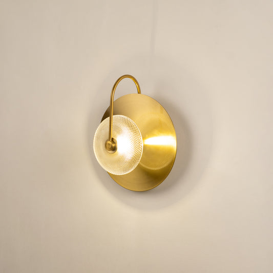 Elegant gold metal wall sconce with soft warm light fixed on neutral wall background ideal for minimal luxury interior lighting setup.