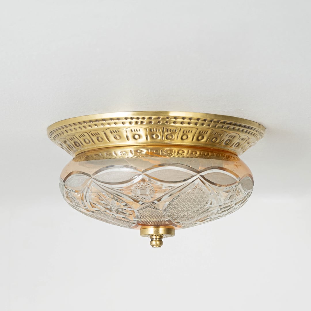 Vintage brass and glass flush ceiling light installed on white ceiling adding classic charm to home interior setting.
