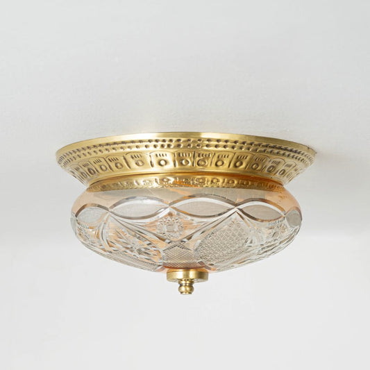 Vintage brass and glass flush ceiling light installed on white ceiling adding classic charm to home interior setting.