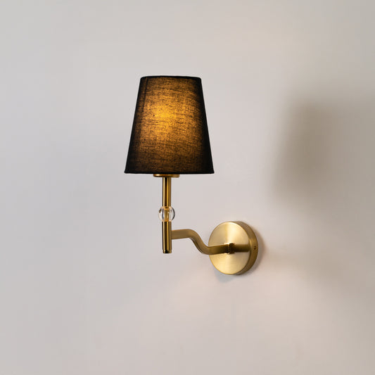 Elegant wall light in gold metal finish with dark fabric shade for bedroom or living room decor lighting white background.