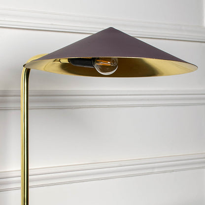 Closeup of gold metal table lamp with brown shade showing sleek curved stand and modern geometric design.