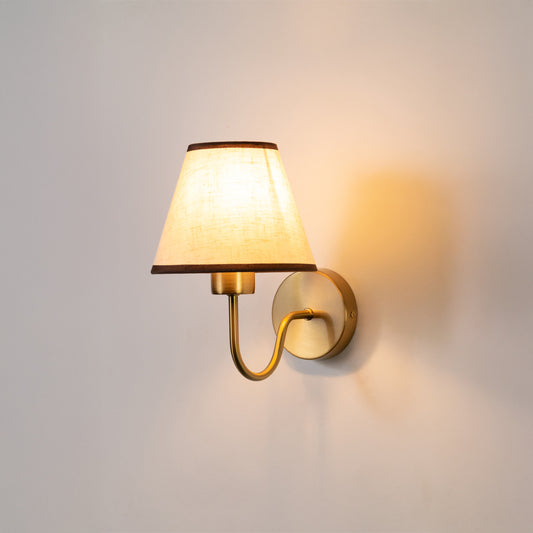 Modern wall light in gold metal finish with fabric shade for bedroom or living room decor lighting white background.
