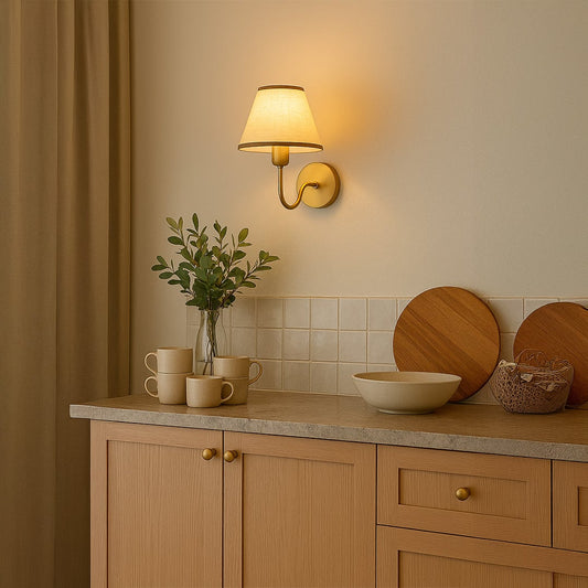 Gold metal wall sconce with beige fabric shade styled in a modern room adding warm soft glow for elegant home wall decor.
