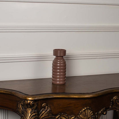 Terracotta brown ceramic column vase with a bold stacked horizontal ribbed pattern displayed on a classic console table.