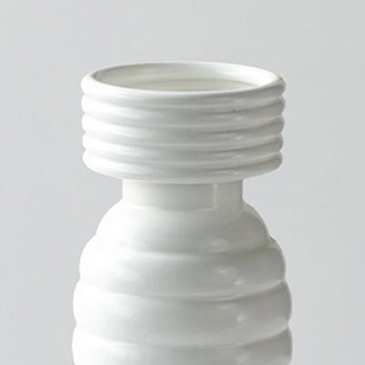 Sender closeup image of a glossy white ceramic totem vase featuring stacked ribbed tiers and a wide horizontally grooved neck.