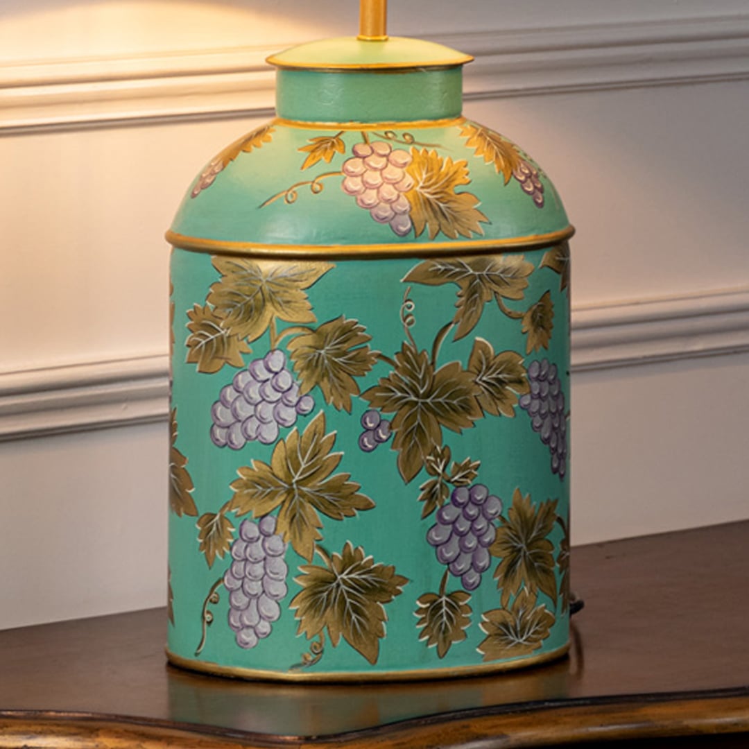 Table lamp closeup showcasing a turquoise ceramic base with colorful floral artwork and refined decorative detailing.