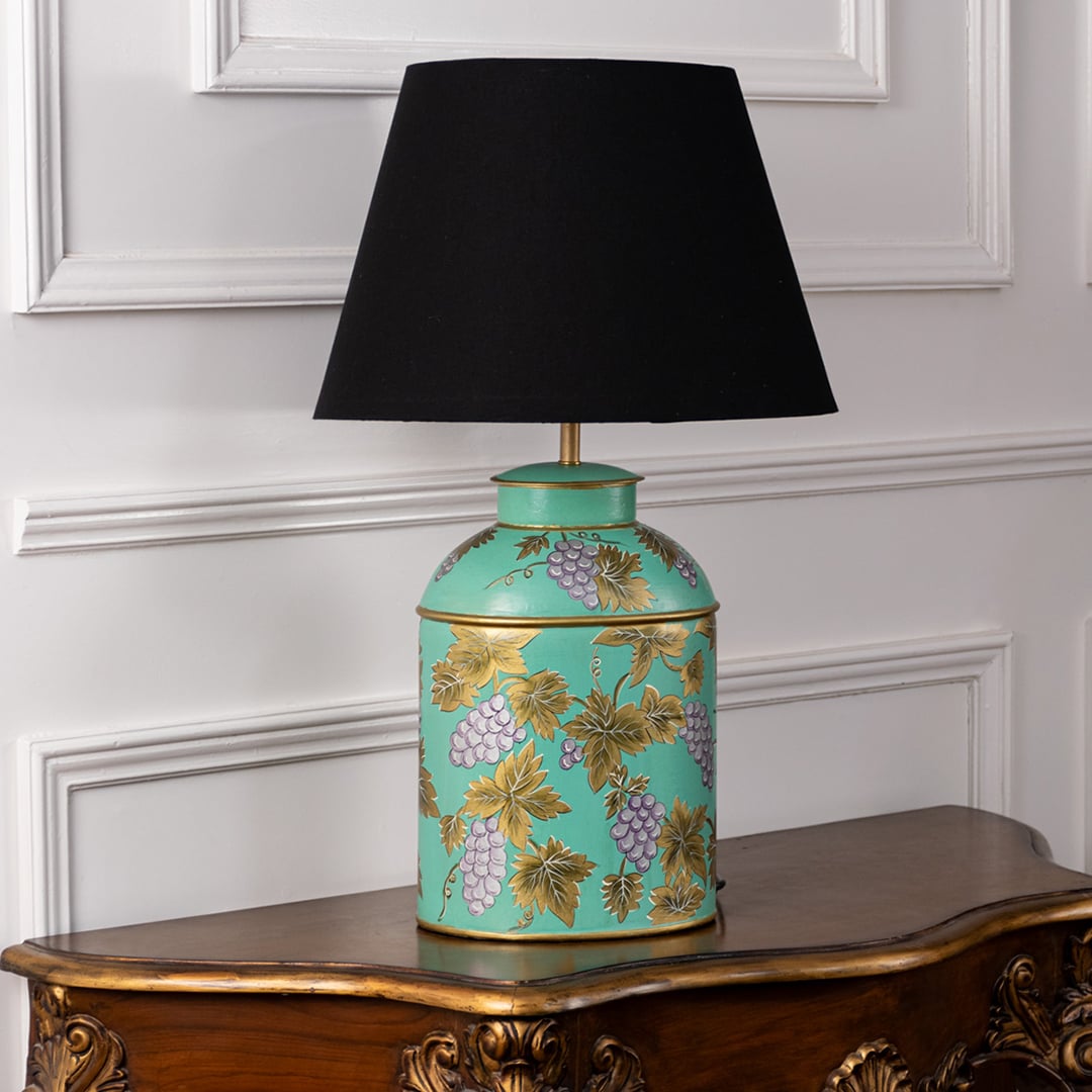 Palais mint green hand painted ceramic lamp with black fabric shade turned off on white background showing grapevine artwork.