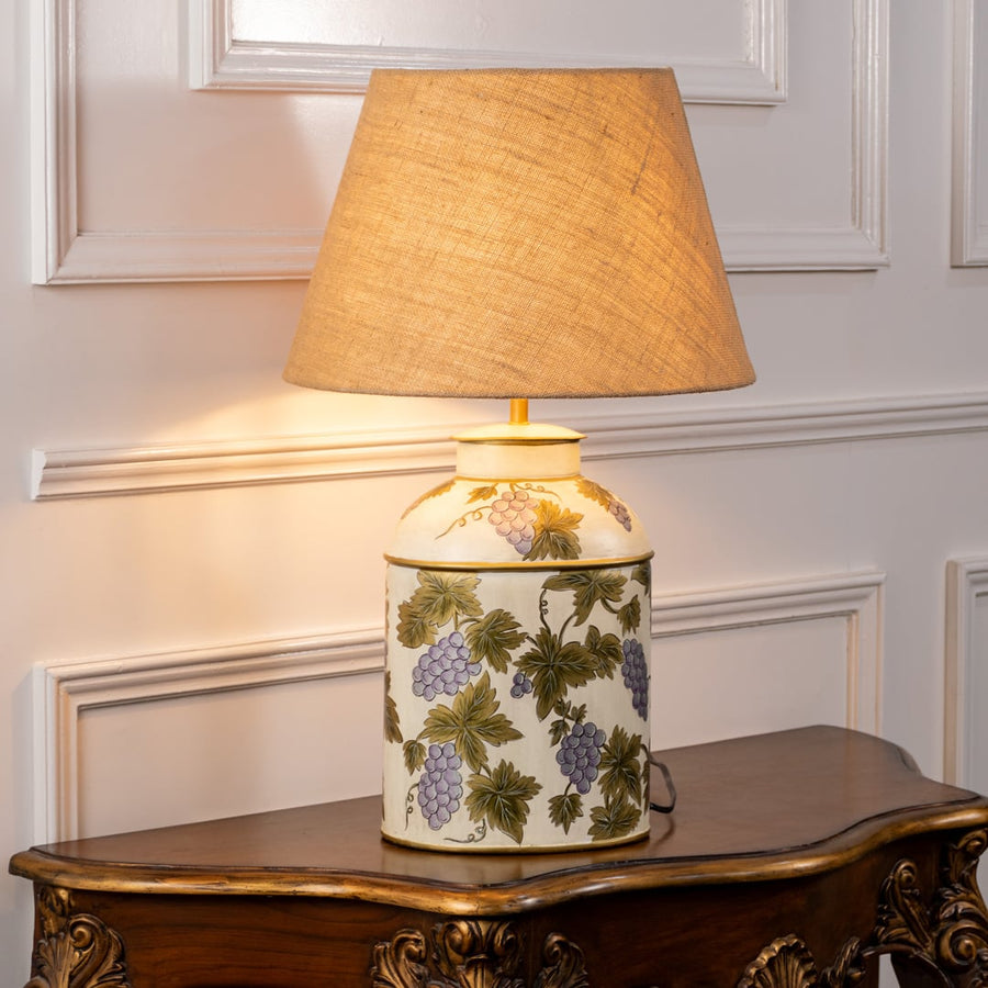 Grape Vine white table lamp on white background with light on displaying delicate vine pattern and soft interior illumination.
