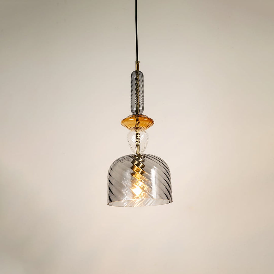 A grey and amber glass ceiling pendant light glows softly against a white background adding a modern ambience to any indoor space.