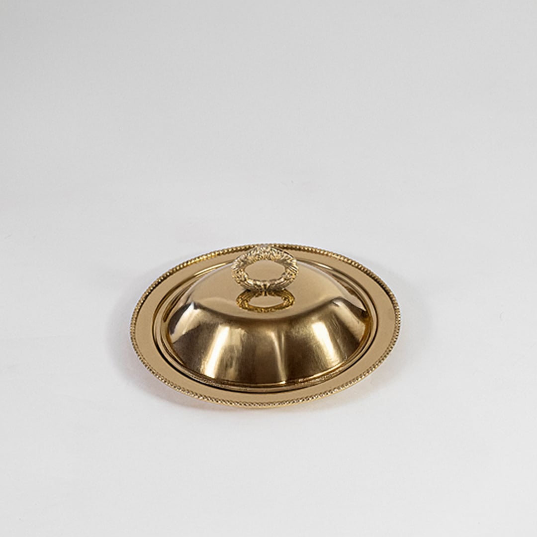 Gold dome lid with round handle displayed on white background highlighting reflective metal and clean design.