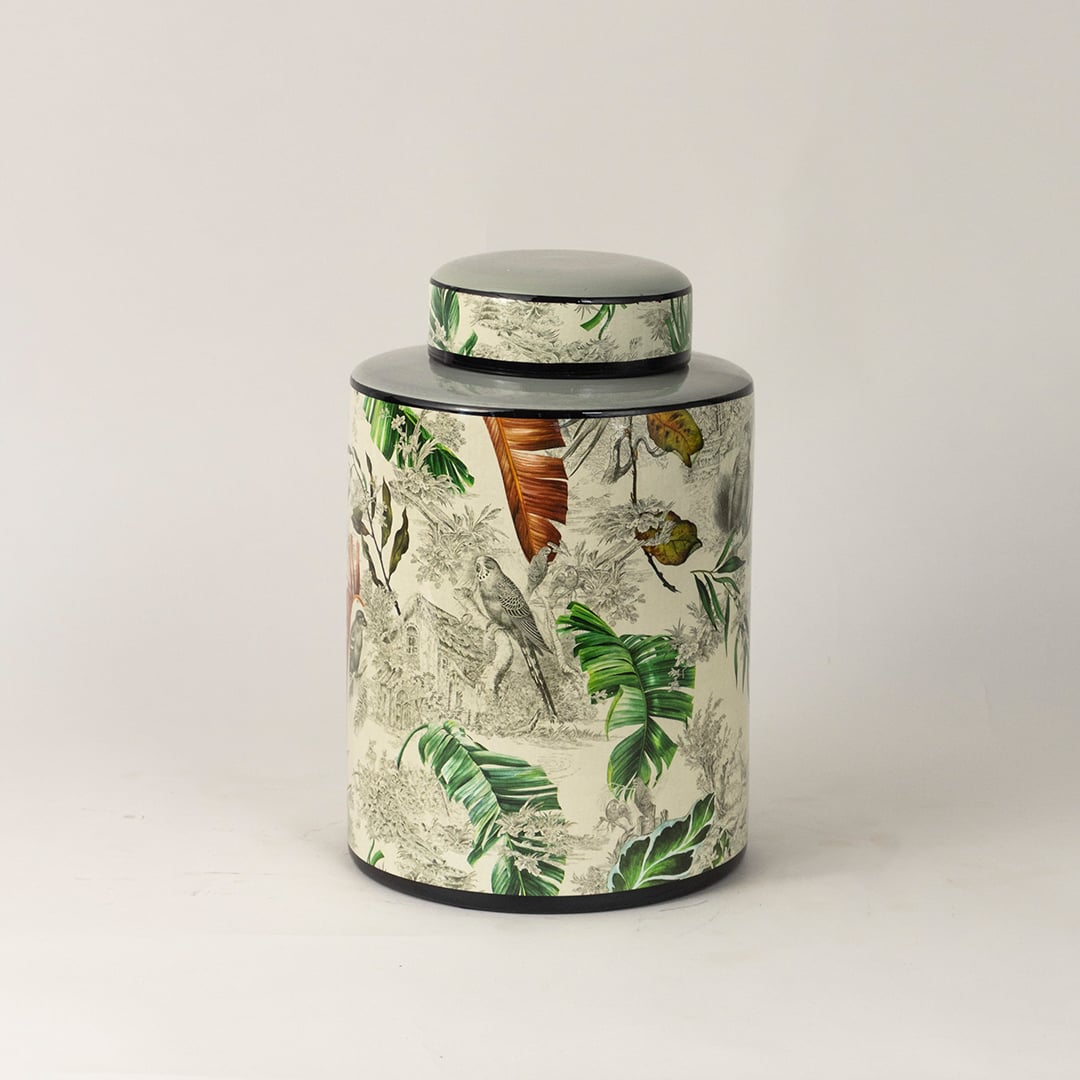 Tropical bird jar captured from side angle showing curved body and detailed bird and leaf artwork.