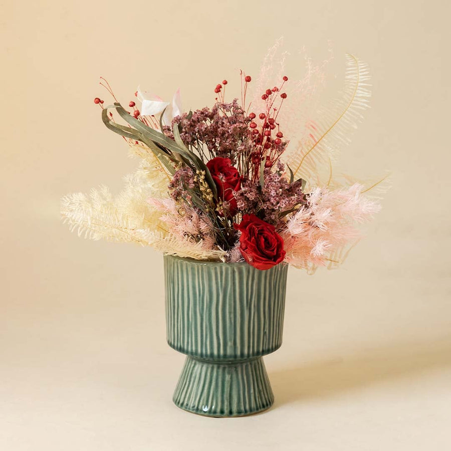 Stylish ribbed green ceramic vase placed in bright interior setup adding artistic charm to modern home styling.