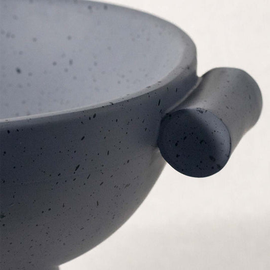 Closeup of blue ceramic decorative bowl with speckled finish highlighting refined craftsmanship and modern styling.