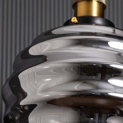 Closeup view highlighting the top brass holder and upper ridges of the smoked glass pendant light revealing fine craftsmanship and smooth reflective finishes.