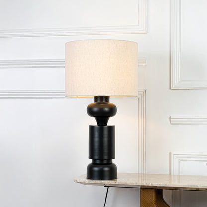 Classic table lamp in black base with fabric shade for bedside or living room decor lighting placement white background.