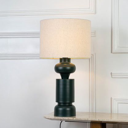Elegant table lamp in green base with fabric shade for bedside or living room decor lighting placement white background.