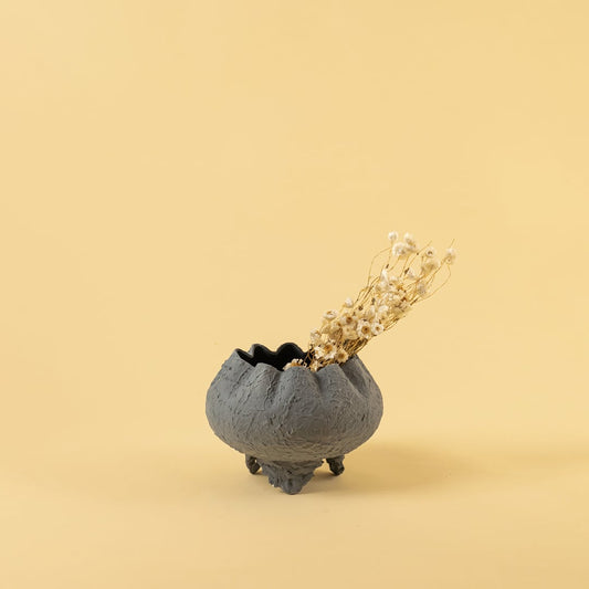 Grey metal scalloped bowl planter decor styled in a warm modern space adding a subtle elegant accent to living room tables.