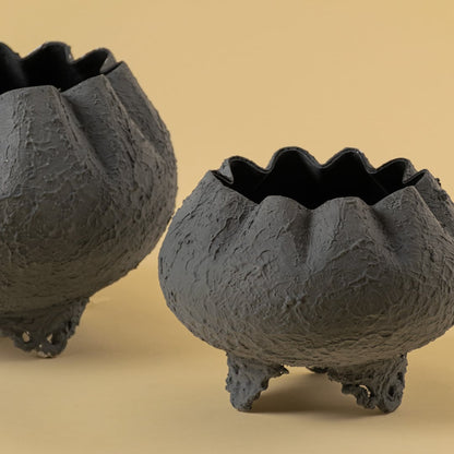 Closeup of grey metal scalloped bowl planter showing textured detailing and ornate base perfect for stylish home decor accents.