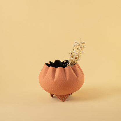 Small textured terracotta bowl planter with dried stems for warm modern home decor and minimalist table style.
