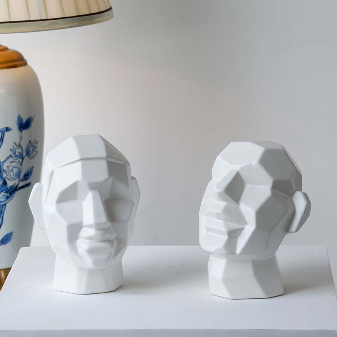 Pair of white geometric head sculptures with faceted surfaces perfect for minimalist modern interior styling.