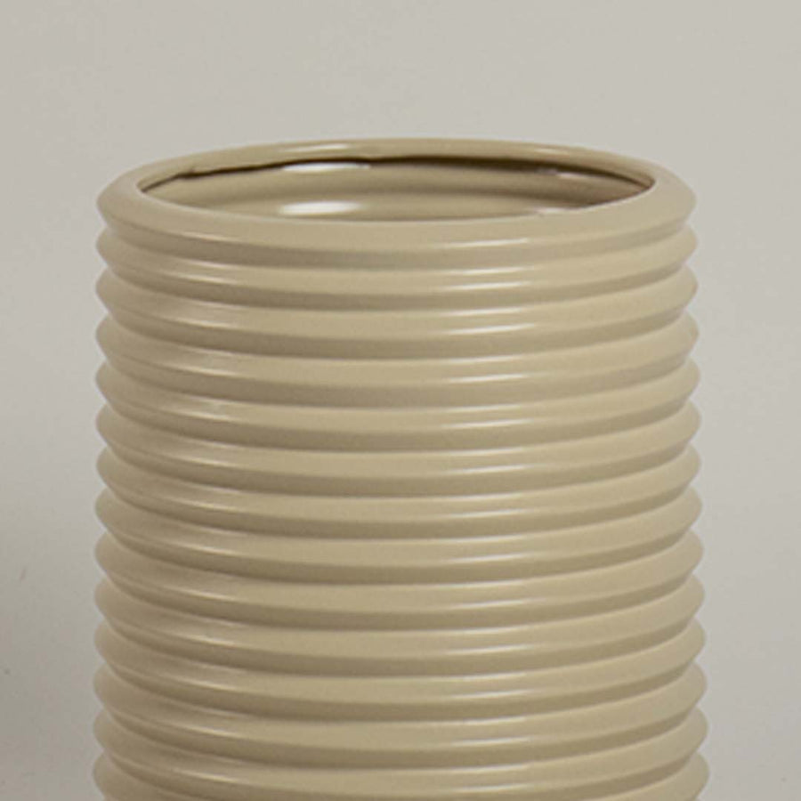 Closeup of beige ribbed ceramic vase showing glossy finish and smooth detailing ideal for floral arrangement styling.