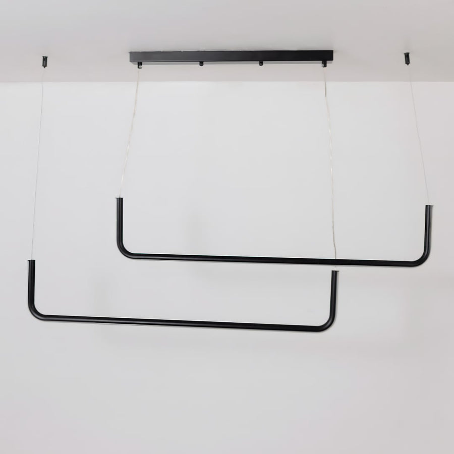 Black hanging light displayed on a white background with lights off showing its minimal modern dual bar structure clearly.