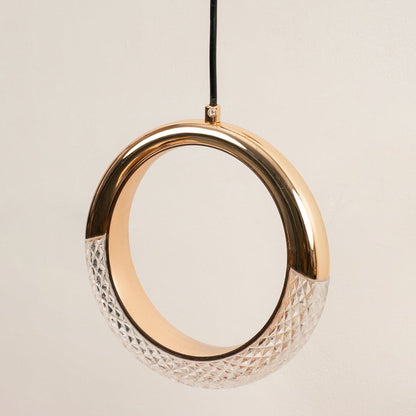 Closeup of gold circular pendant light with crystal detail showcasing luxurious craftsmanship and glow.