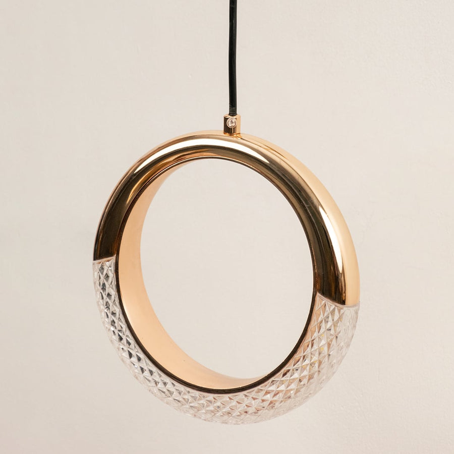 Closeup of gold circular pendant light with crystal detail showcasing luxurious craftsmanship and glow.