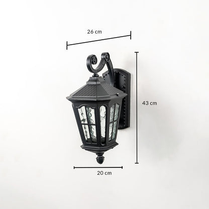 Outdoor wall light with ornate lantern design black frame and glass panels shown with 43 cm height 26 cm width 20 cm depth.