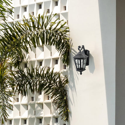 Elegant outdoor wall light with vintage lantern design mounted on white exterior wall for stylish home entrance lighting.
