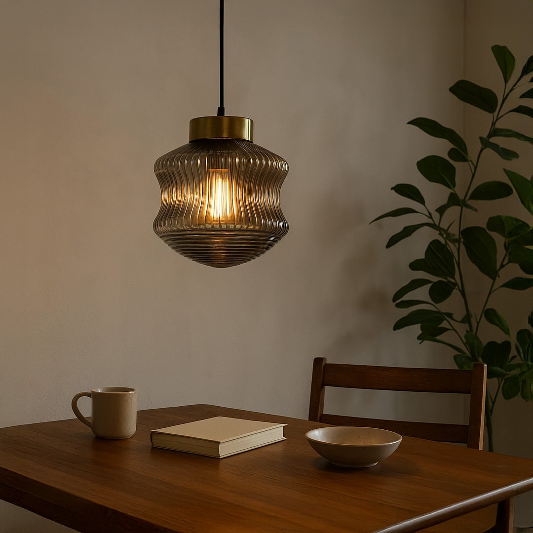 Ribbed smoked glass pendant light with warm glowing bulb hanging above a wooden dining table creating a cozy modern atmosphere in a neutral interior.