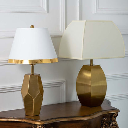 Gold faceted table lamps with white tapered shades shown together with lights off highlighting elegant geometric bases for modern home styling.