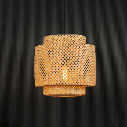 Handwoven rattan pendant light with layered bamboo shade turned on glowing softly against black background.